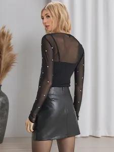 Detailed back view of a chic black PU leather mini skirt with silver rivet accents.