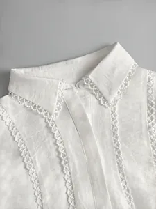 Detailed shot of white blouse showing delicate lace trim and textured collar