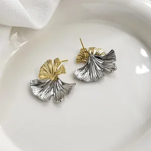 Gros plan de boucles d'oreilles feuille de ginkgo bicolores à texture plissée