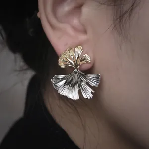 Détail macro de boucles d'oreilles élégantes en forme de feuille de ginkgo bicolore