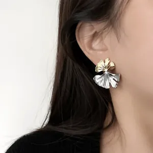 Gros plan de boucles d'oreilles feuilles de ginkgo bicolores dorées et argentées