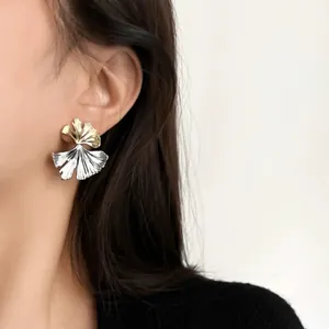 Vue détaillée d'une boucle d'oreille en feuille de ginkgo bicolore aux tons or et argent