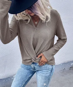 Close-up detail of waffle knit top showing twisted knot hem and textured fabric finish