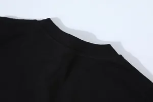 Detailed view of the reinforced ribbed round neckline on a black slim-fit cotton T-shirt