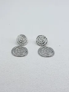 Detailansicht der unregelmäßigen silbernen Spiral-Ohrhänger mit Metallstruktur.