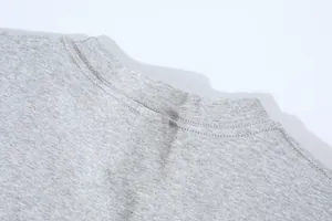 Macro detail view of the gray crew neck and shoulder stitching on a cotton crop T-shirt.