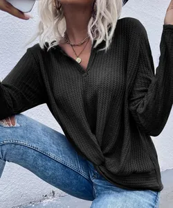Detail view of waffle knit long sleeve top featuring a front twist knot and V-neck