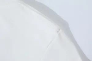 Macro detail showing the high-quality shoulder seam stitching on a white slim fit t-shirt