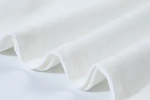 Macro detail of white ribbed knit fabric showing fine texture and stitching