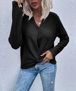 Close-up detail of black waffle knit top featuring a V-neck and stylish front twist knot.