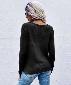 Back view of black long-sleeved waffle knit top showcasing textured fabric and fit.