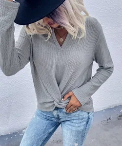 Detail of grey waffle knit long sleeve top with stylish twist knot and V-neckline