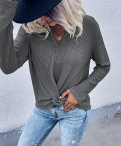 Close-up of grey waffle knit v-neck top featuring a stylish front twist knot detail.