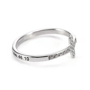 Detalle de un anillo de acero inoxidable con cruz y grabado del Salmo 46:10.
