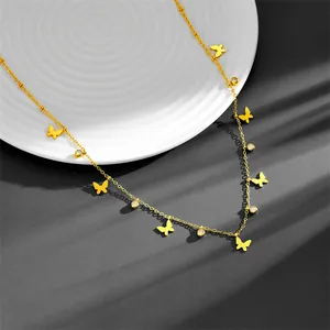Macro detail of a gold-plated stainless steel necklace with butterfly charms and crystals