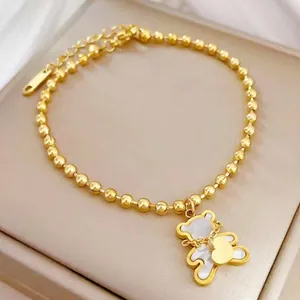 Bracelet élégant en acier titane doré avec pendentif ours en nacre blanche et cœur.