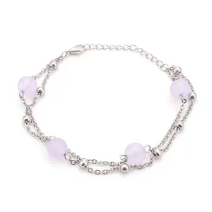 Detalle de una pulsera de plata de doble capa con cuentas de cristal de color lila.