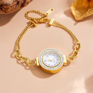 Detailed macro view of elegant crystal-set gold round watch with a double-layer chain