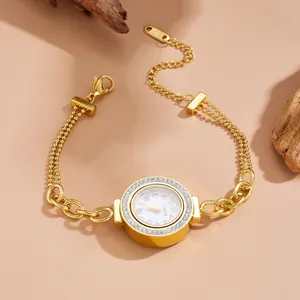 Detailed view of a gold bracelet watch with crystal bezel and double layer chain.
