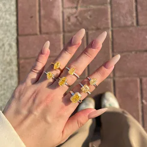 Close-up of sparkling yellow ice-cut zircon rings on a hand in natural outdoor sunlight