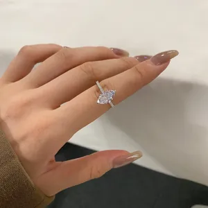 Macro view showing the detail of a marquise-cut zirconia ring on a woman's finger.