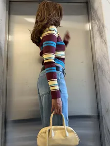 Détail d'un haut en maille à manches longues cintré con rayures multicolores élégantes