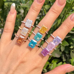 Close-up of vibrant radiant-cut colorful zircon rings on a hand in natural light.