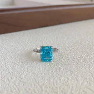 Close-up of the radiant blue emerald-cut gemstone and pave-set silver band detail