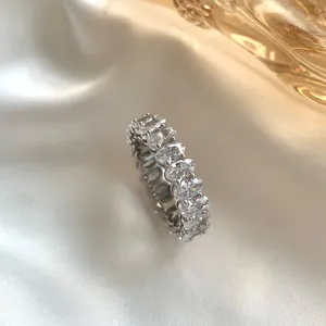 Detailed close-up of a silver full eternity ring with oval-cut white zircons