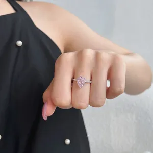 Close-up detail of a pear-cut pink gemstone silver ring worn on a woman's finger