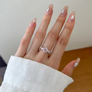 Detailed close-up view of a pink zircon flower ring in S925 sterling silver on a hand.