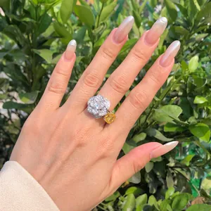 Elegante anillo de rosa en plata S925 con circón amarillo usado en el dedo, detalle de joya.