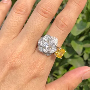 Detalle de un anillo de flor en plata S925 con circonitas blancas y amarillas en la mano