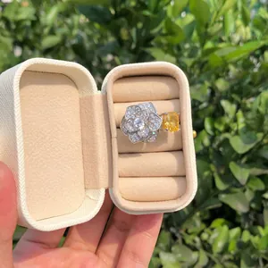 Primer plano de anillo de plata S925 con diseño de flor y circonitas amarillas y blancas.