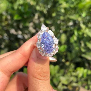 Vista detallada de un anillo de lujo con circón azul talla pera y halo de cristales
