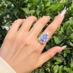 Anillo de plata S925 en la mano con circonita de hielo lavanda en corte de pera central