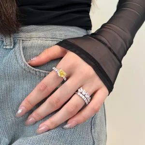 Close-up of hand wearing S925 silver rings with yellow heart stone and layering diamond bands