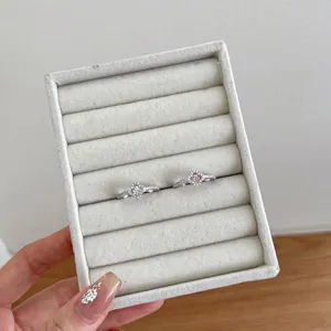 Detailed macro view of two S925 sterling silver heart rings with pink and clear stones.