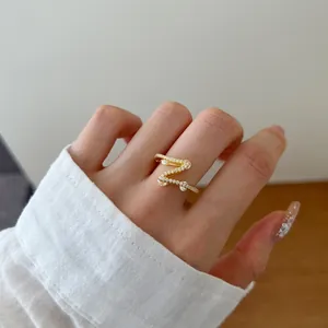 Detailed view of an elegant gold S-shaped S925 silver ring with cubic zirconia stones.