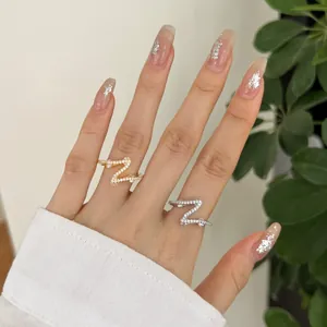 Detailed view of silver and gold Z-shaped rings set with sparkling cubic zirconia stones