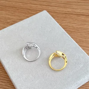 Macro detail of silver and gold plated rings with sparkling zircon inlay on gray felt base
