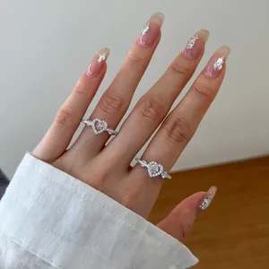 Close-up of heart-shaped silver rings with pink and clear cubic zirconia