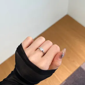 Detail shot of minimalist S925 sterling silver heart ring on a female model's hand