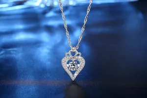 Detailansicht einer funkelnden Herz-Halskette mit Krönchen und einem Zirkonia-Stein.