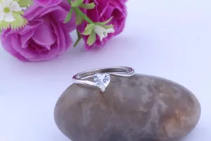Close-up of elegant silver-colored ring featuring a heart-shaped cubic zirconia stone