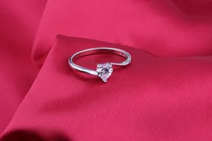 Detailed close-up of a silver heart-shaped zircon ring with S925 hallmark on red satin