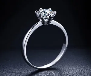 Side view detail of a classic six-prong silver ring with a sparkling clear zircon