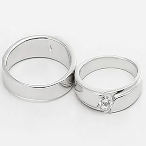 Macro view of polished silver-toned couple rings featuring marquise-cut zircon stone detail
