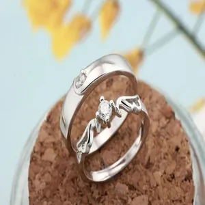 Detailed macro shot of silver-tone couple rings featuring brilliant zircon stones