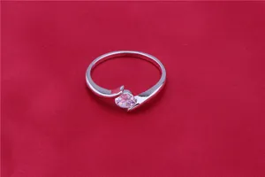 Detailed macro view of a silver-tone crossover ring with a sparkling round zircon stone.
